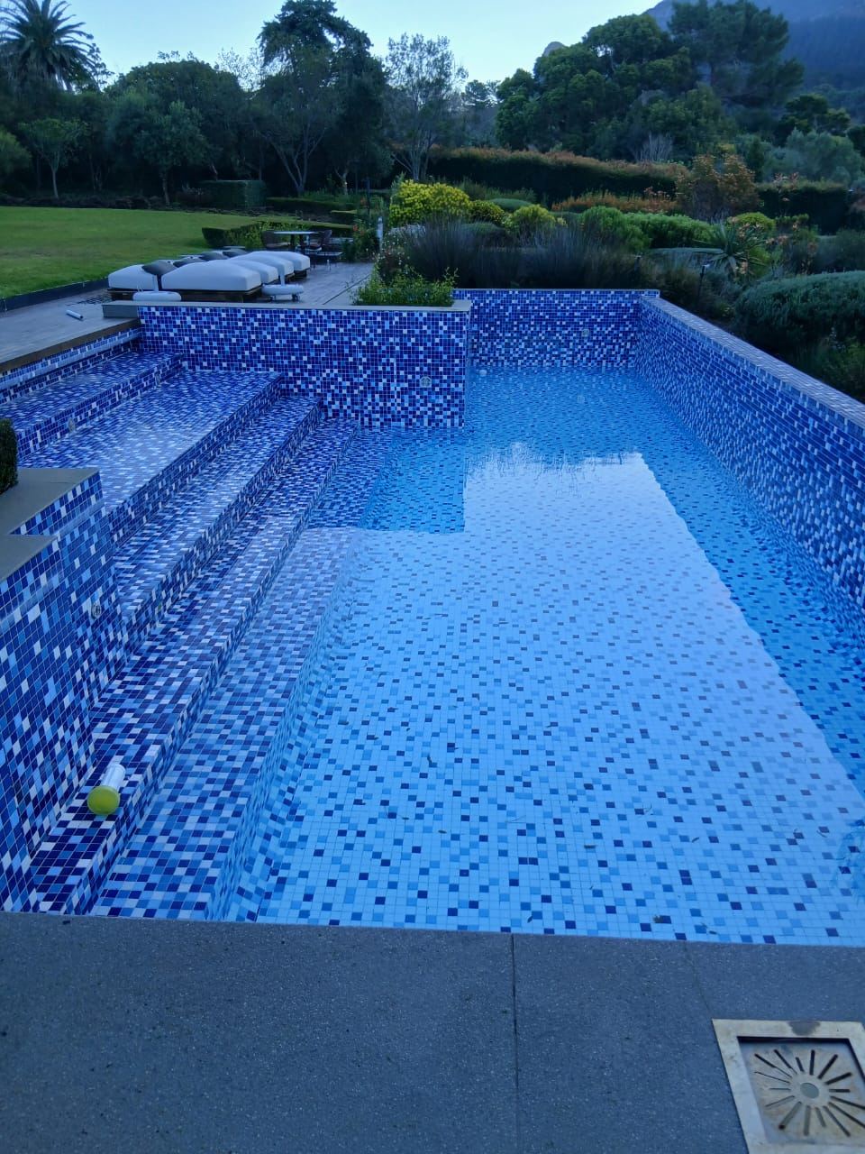 Blue mosaic tiled pool at dusk