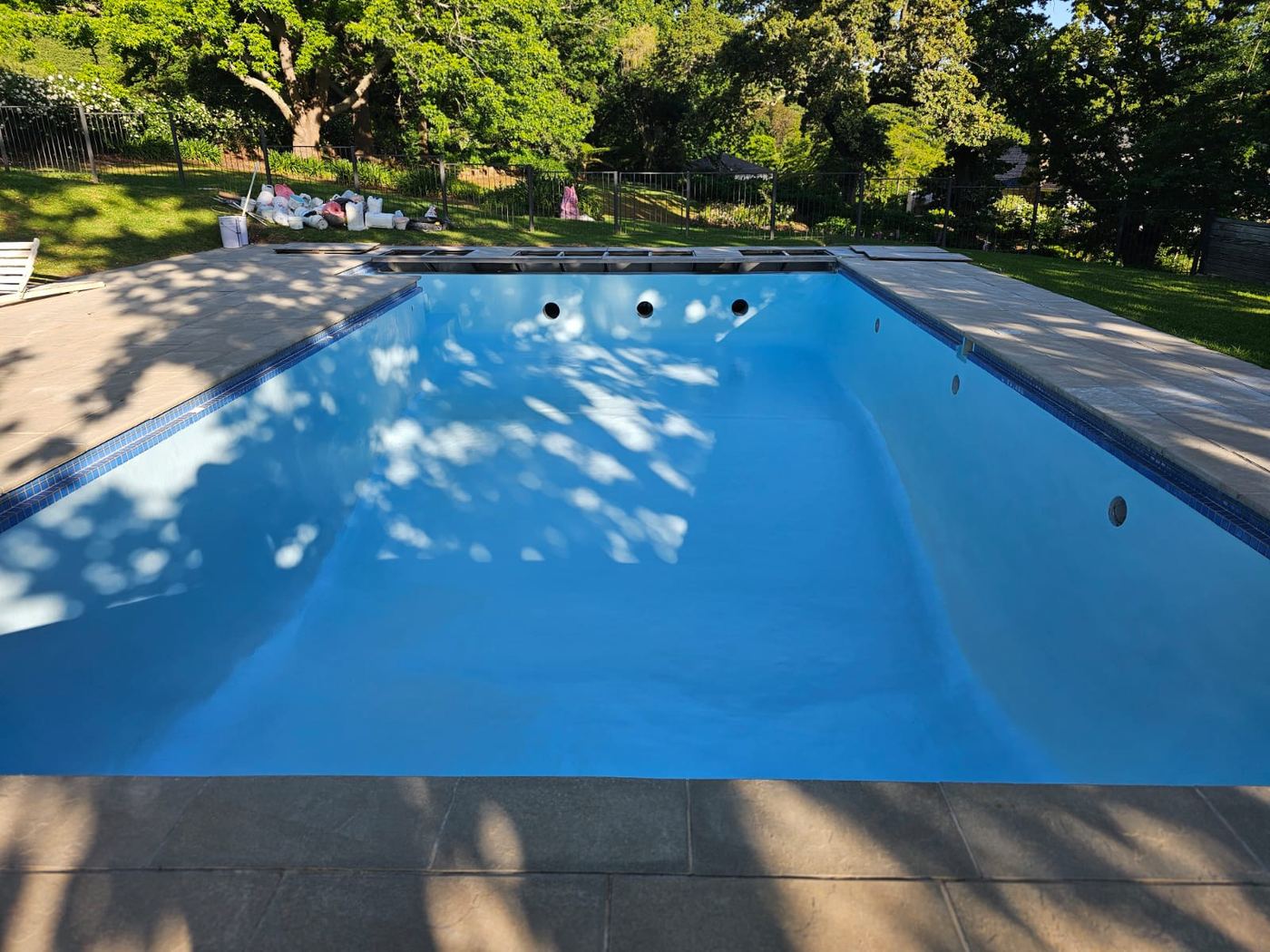 Large re-marbled pool in a leafy garden