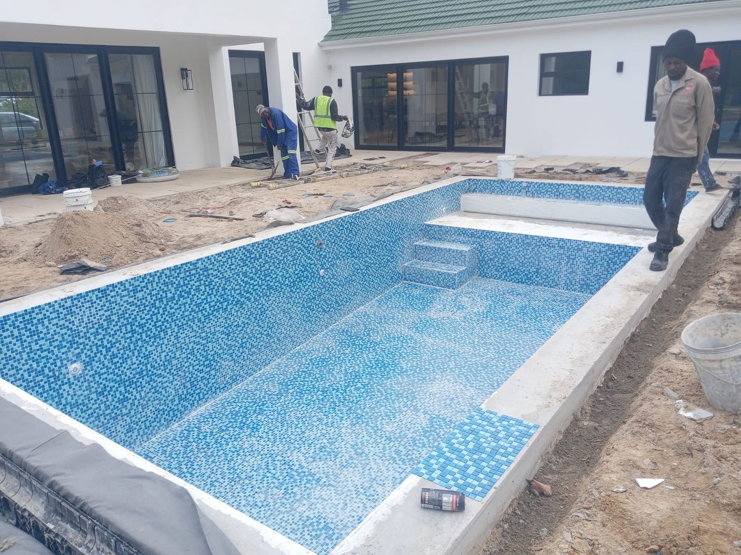 The Pool Crew team tiling a new pool build from the ground up